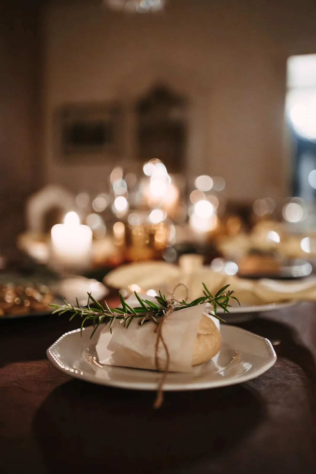 Bread tied with twine and rosemary in an elegant dinner setting