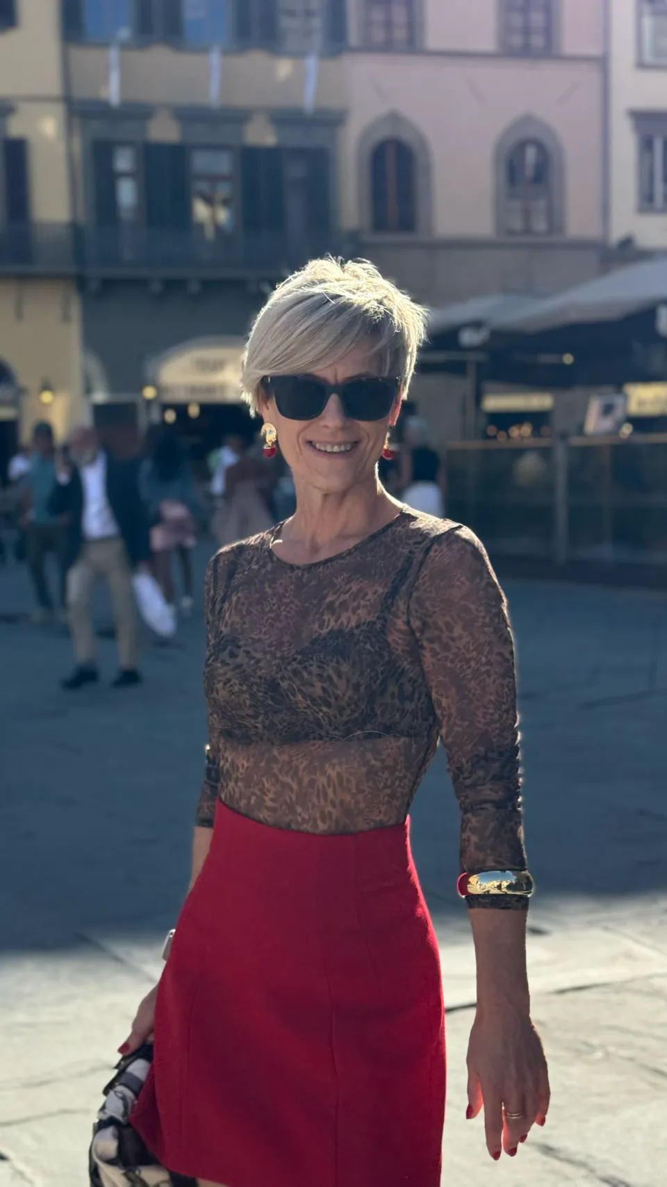Rita wearing red and leopard print in an Italian town square.