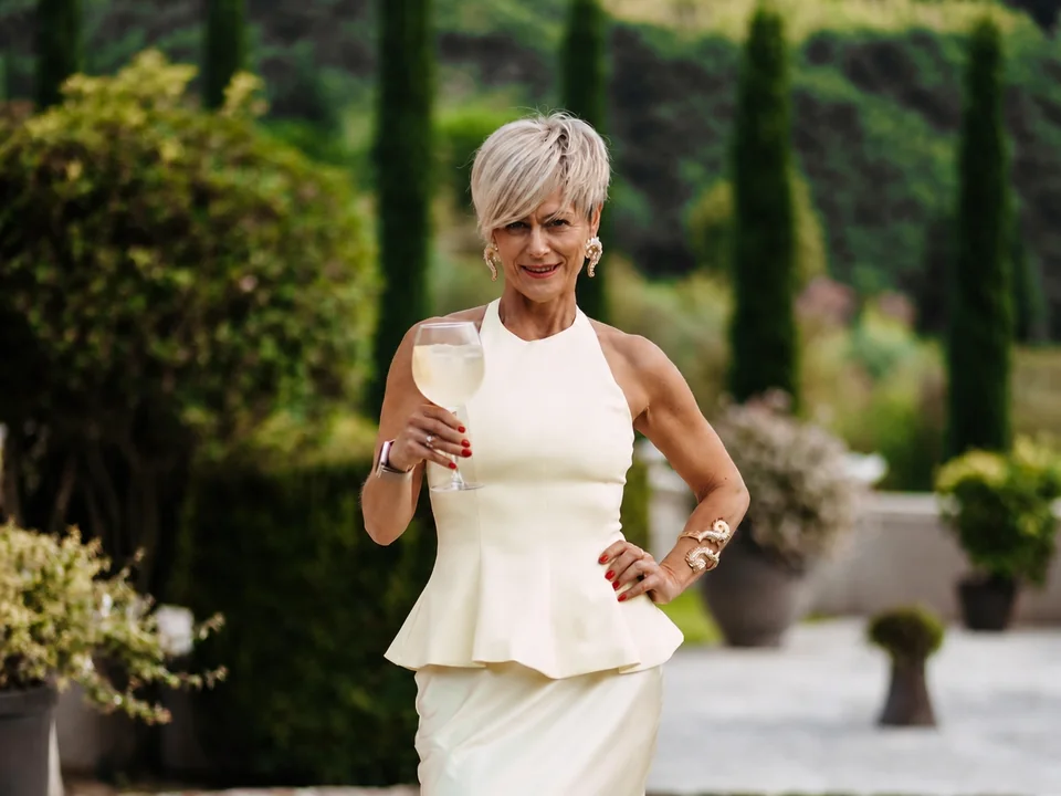 Rita in a white outfit in an Italian garden